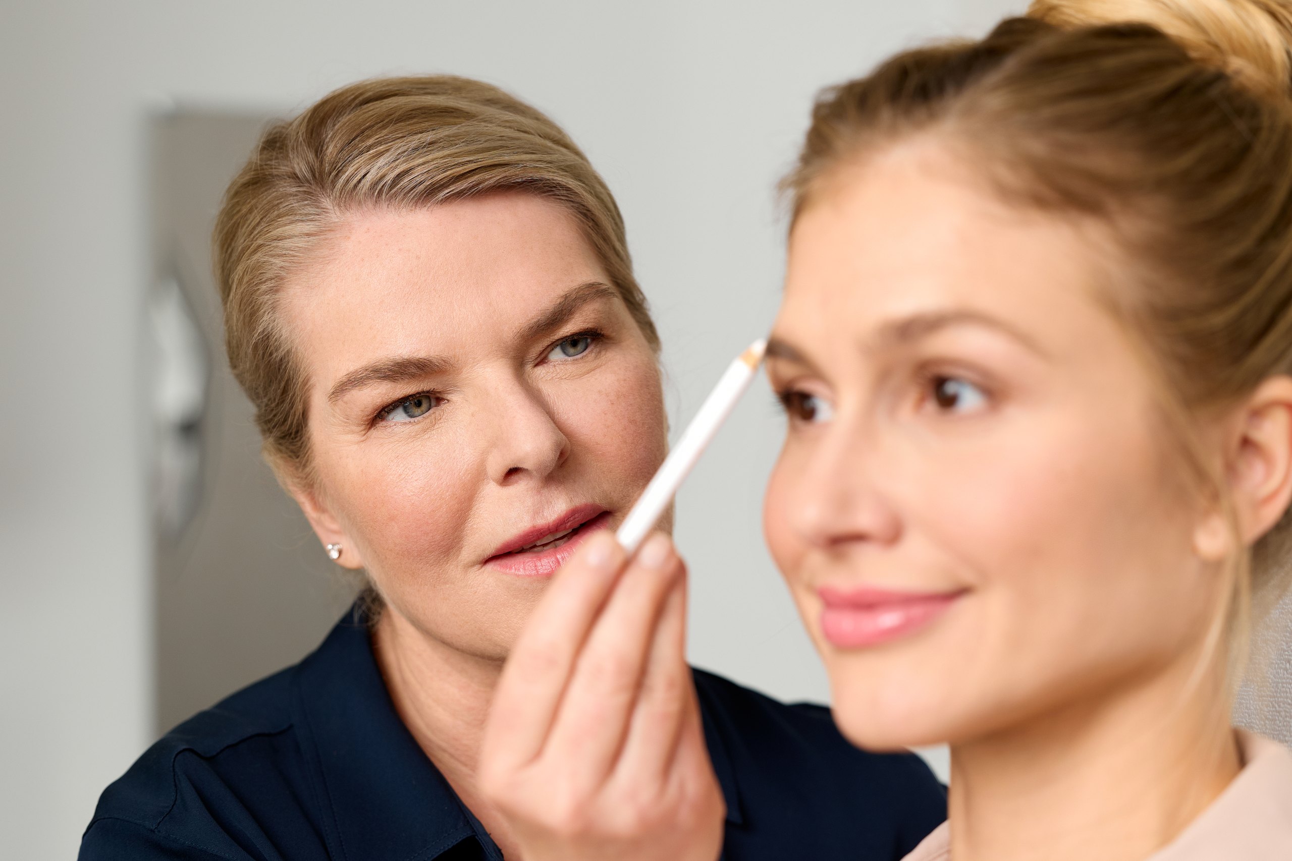 Ärztin der Hamburg Dermatologie markiert Behandlungsareale im Gesicht einer Patientin